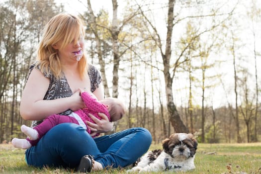 Mother is having a trip with the baby and dog outside