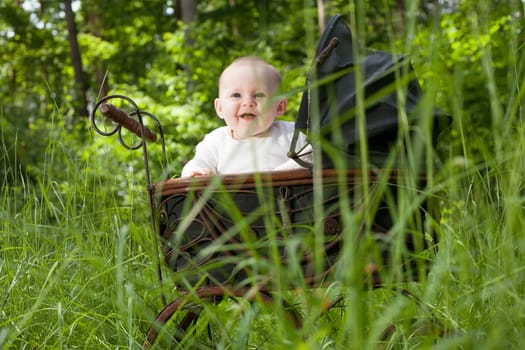 Baby girl is sitting in a vintage pram