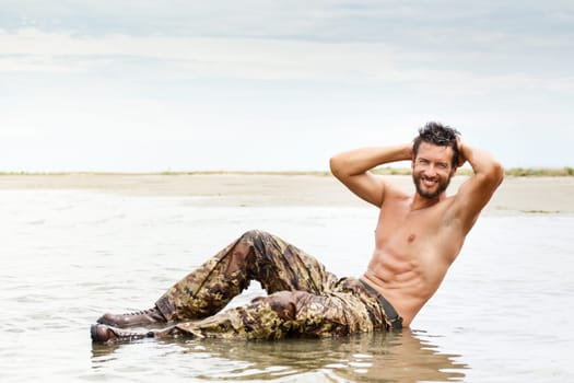 Portrait of Muscle man during fitness training on the water ocean