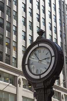 Street clock on the street in Manhattan. Skyscrapers in the background.