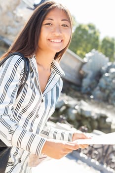 Smiling asian tourist holding a city tour map