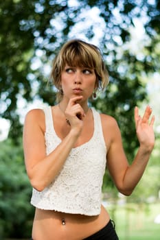 Attractive blonde young woman outdoors with funny expression on her face