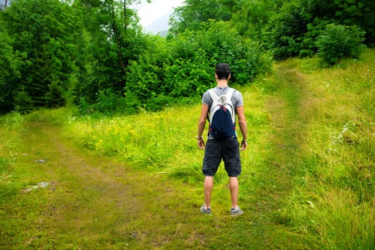 Young man facing choice between two different paths. Concept of choosing between options