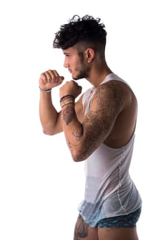 Handsome sporty young man in a boxing pose. side view. Isolated on white