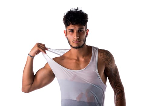 Strong and healthy young man posing in tank top isolated on white
