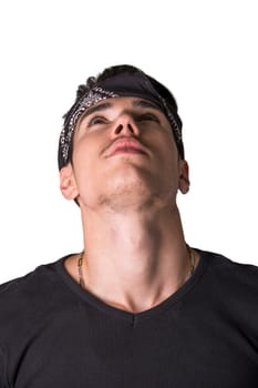 Handsome young man in a headband standing thinking with his head tilted right back as he stares pensively at the sky, isolated on white