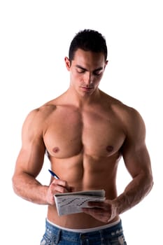 Shirtless attractive young man solving crosswords puzzles published in a printed magazine, portrait on white