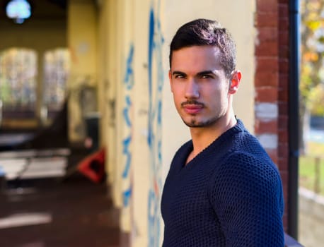 Handsome young man in grunge building looking at camera