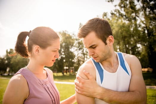 Woman assists to man with injured shoulder