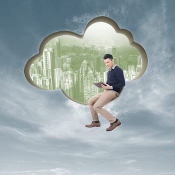 Cloud concept with man sit at a cloud shaped wall and using tablet.