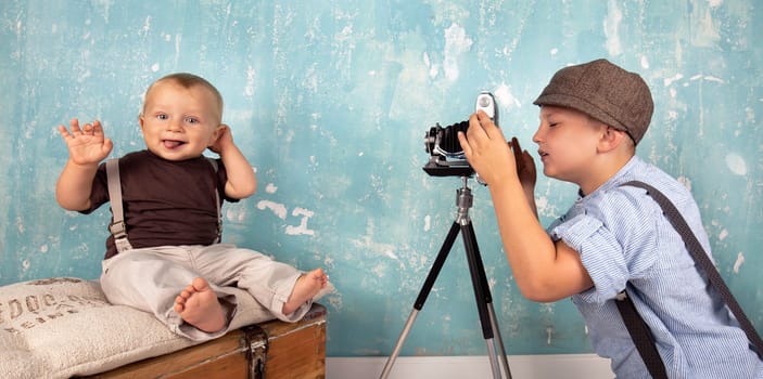 little boy takes pictures of his brother