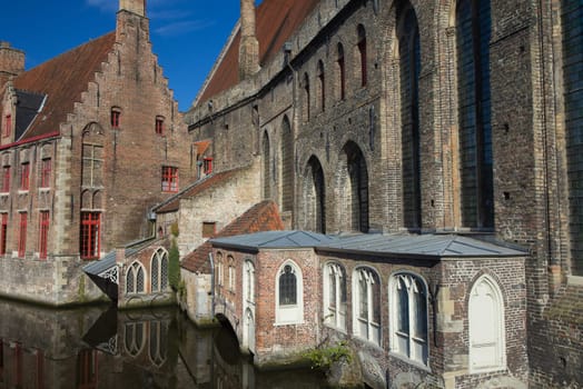 Historic houses lining the peaceful canal. Bruges (Belgium)