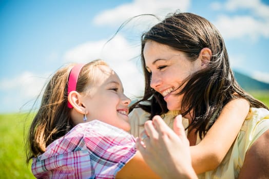Mother and child are hugging and having fun outdoor in nature