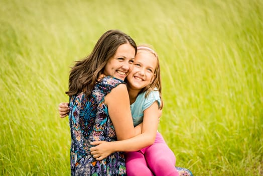 Mother and child are hugging and embracing outdoor in nature