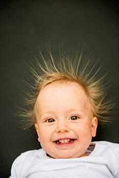 Portrait of smiling baby with standing hair from static electricity