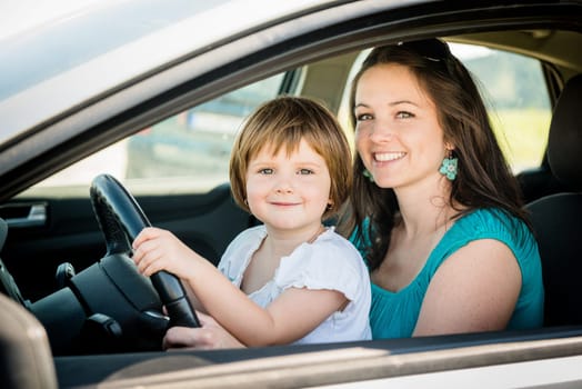 Portrait of mother and child pretend driving car sitting both on front driver seat