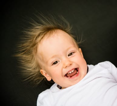 Portrait of laughing baby with standing hair from static electricity