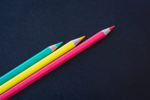 Different color pencils sharpened on dark background, stock photo
