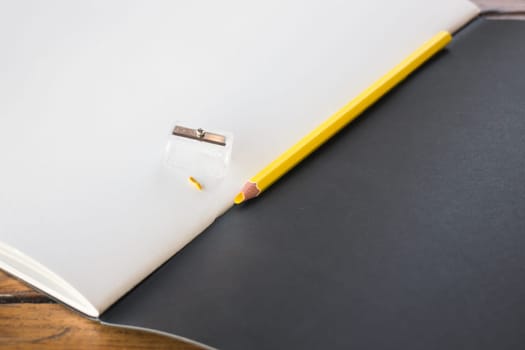 Broken yellow pencils on sketchbook, stock photo