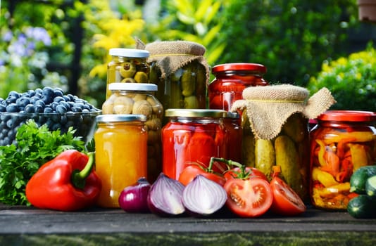 Jars of pickled vegetables in the garden. Marinated food.