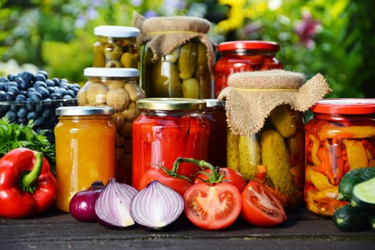 Jars of pickled vegetables in the garden. Marinated food.