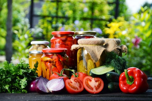 Jars of pickled vegetables in the garden. Marinated food.