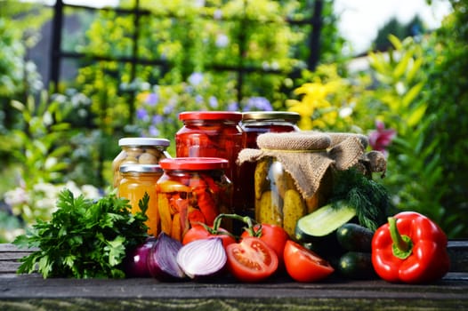 Jars of pickled vegetables in the garden. Marinated food.