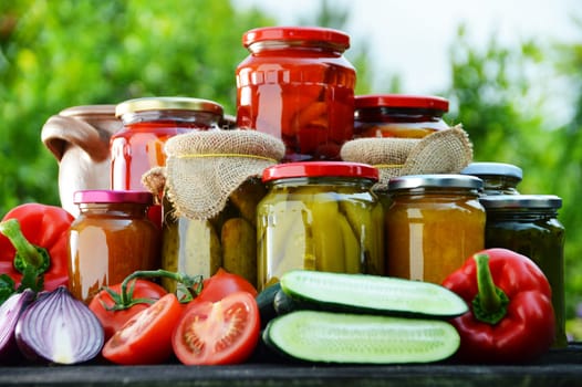 Jars of pickled vegetables in the garden. Marinated food.