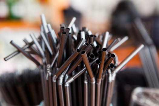 Glass full of black straw over outdoors bar desk