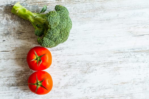 Tomatos and broccoli background with copy space.