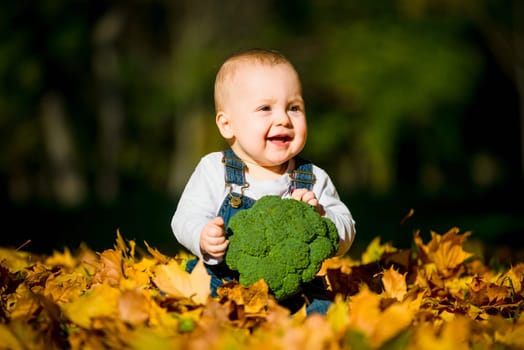 Beautiful baby girl eating food outdoor in nature