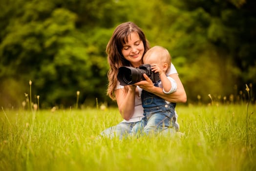 Mother showing her baby photos on DSLR camera outdoors