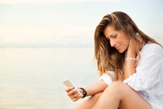 Portrait of Smiling beautiful young woman using a mobile phone