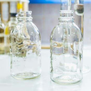 Empty glass bottles on table. Research laboratory glassware