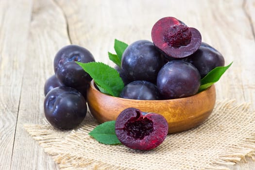 fresh plums in a bowl wooden background