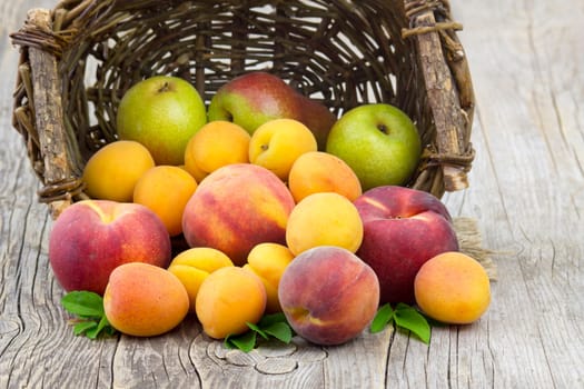 fresh fruits in a basket on wooden background