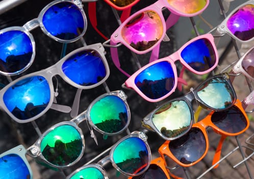 bunch of retro style sunglasses on a rack in front of a store