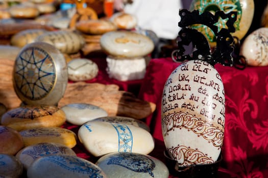 Colored pebbles painted with mandala drawings for sell
