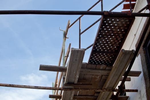 Rural building facade under reconstruction with old scaffoldings