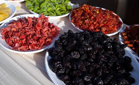 Assorted dried fruits in big white plates, ready for sell