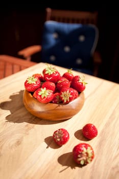 Fresh strawberries in wood bowl on table