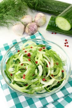 a bowl of cucumber salad with dill and red pepperberries