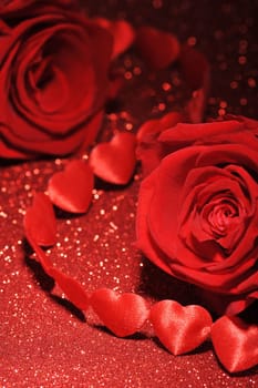 Chain of red fabric hearts with red roses on glitter background