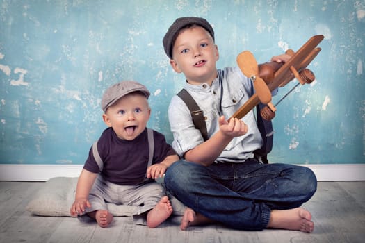 two brothers playing with wooden planes