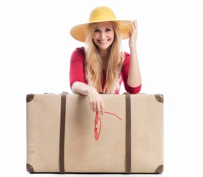 a laughing woman sits behind a suitcase