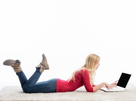 a woman lies in a belly position on the laptop