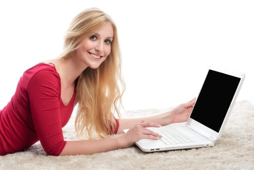 a woman lies in a belly position on the laptop