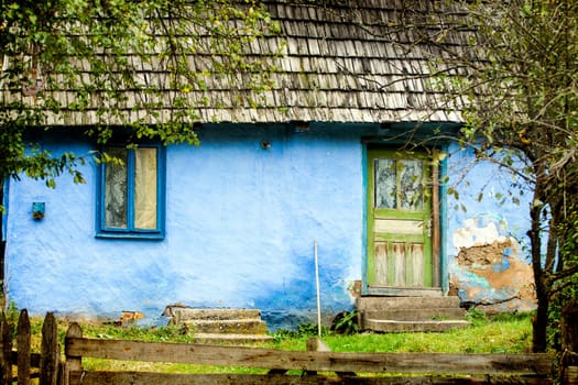 Vintage photo of old rural house in autumn forest