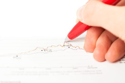 Close-up of female hand holding pen over business graph