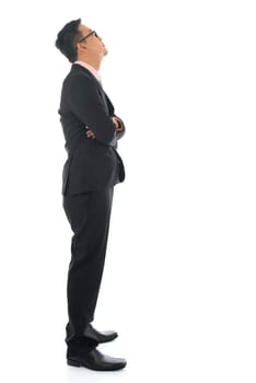 Full length confident southeast Asian business man crossed arms looking away standing isolated on white background.